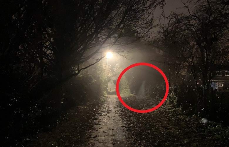 Silhouette fantôme capturée sur un sentier de nuit